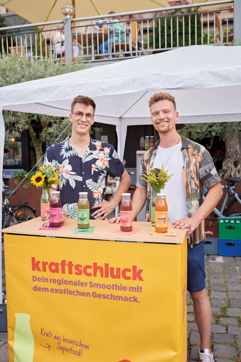 Fotounterschrift: Die Gründer von Kraftschluck präsentieren ihren Bio-Smoothie „ohne Jetlag“ auf dem AgriKulturfest am Hauptmarkt Nürnberg. Beide Projekte wurden in 2022 durch die Öko-Modellregion gefördert. Foto: E. Wellmann