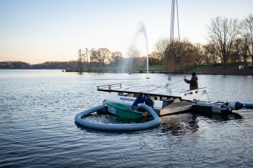 Mitarbeiter der Spezialfirma aus Freudenstadt lassen eine der schwimmenden Pumpen ins Wasser (Copyright: Stadt Bocholt)