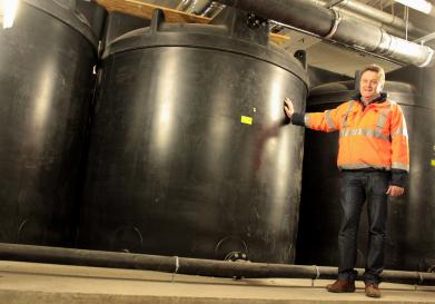 Projektleiter Hugo Tork zeigt die Tanks, die jeweils 10 000 Liter Regenwasser fassen. Foto: Stadt Münster. 