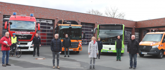 Gemeinsam ein Zeichen setzen:  Vertreter und Vertreterinnen von ADFC, Feuerwehr, Stadtreinigung, Fachbereich Grünflächen und der Stadtbus GmbH zeigen, in welchen Bereichen bereits Abbiegeassistenten an Großfahrzeugen bei der Stadt eingesetzt werden. Für N