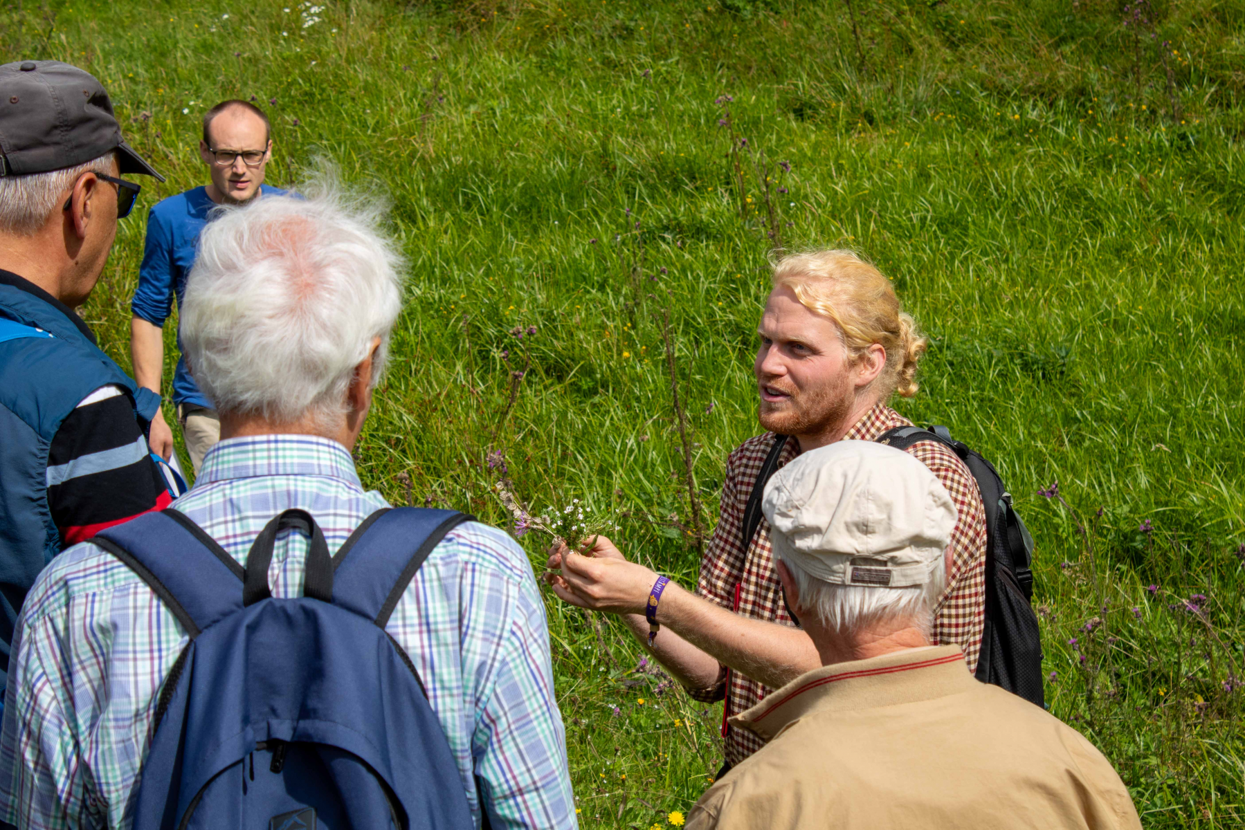 Maverick Henke (rechts), Weide- und Biodiversitätsberater des Landkreises Lörrach, zeigt den Teilnehmenden seltene Pflanzen auf den Wiesen der Familie Frommherz. Fotos: Landratsamt Lörrach/Stefan Heigl