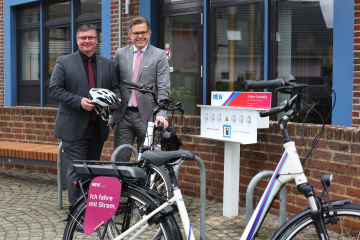 Karl-Heinz Wassong (l.), Bürgermeister der Gemeinde Niederkrüchten, erhielt aus den Händen von NEW-Vorstand Frank Kindervatter zwei Pedelecs, zwei Fahrradhelme und eine Ladestation für die Gemeinde. Foto: NEW AG 