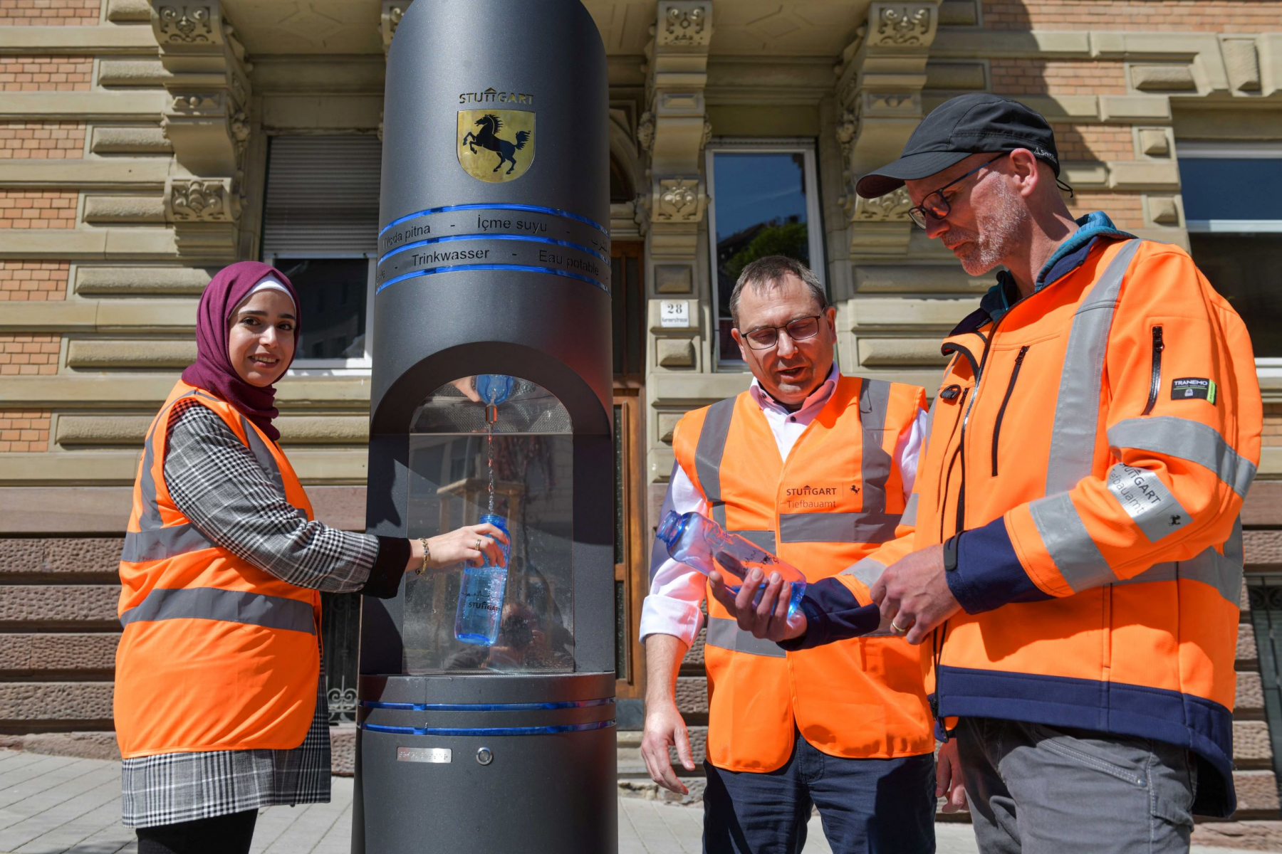 Der neue Trinkbrunnen am Stuttgarter Schützenplatz, der jetzt in Betrieb gegangen ist, mit den drei dafür Zuständigen aus dem Tiefbauamt. Von links: Tasneem Barakat, Klaus Hofmann und Heiko Schrader.