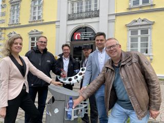 Foto: Stadt Oldenburg  Befüllen einen der „Oldenburger Pfandretter“ am Schloßplatz: Finanzdezernentin Dr. Julia Figura, Torsten von Varel (Abteilungsleiter Straßenreinigung und Werkstatt des AWB), AWB-Betriebsleiter Volker Schneider-Kühn, Michael Götze (V