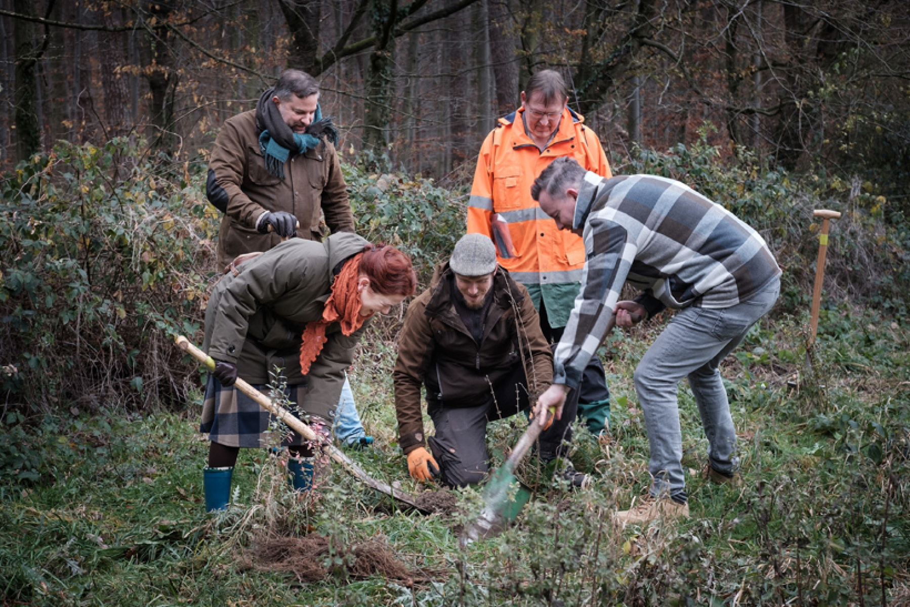 Mit dem Spaten für die Klimawende im Einsatz: (v.r.) SWB-Geschäftsführer Olaf Hermes (gebückt), Stadtförster Harald Heilmann, SDW-Mitarbeiter Edward Olson (kniend), Oberbürgermeisterin Katja Dörner (gebückt) und SDW-Geschäftsführer Christoph Rullmann. (Fo