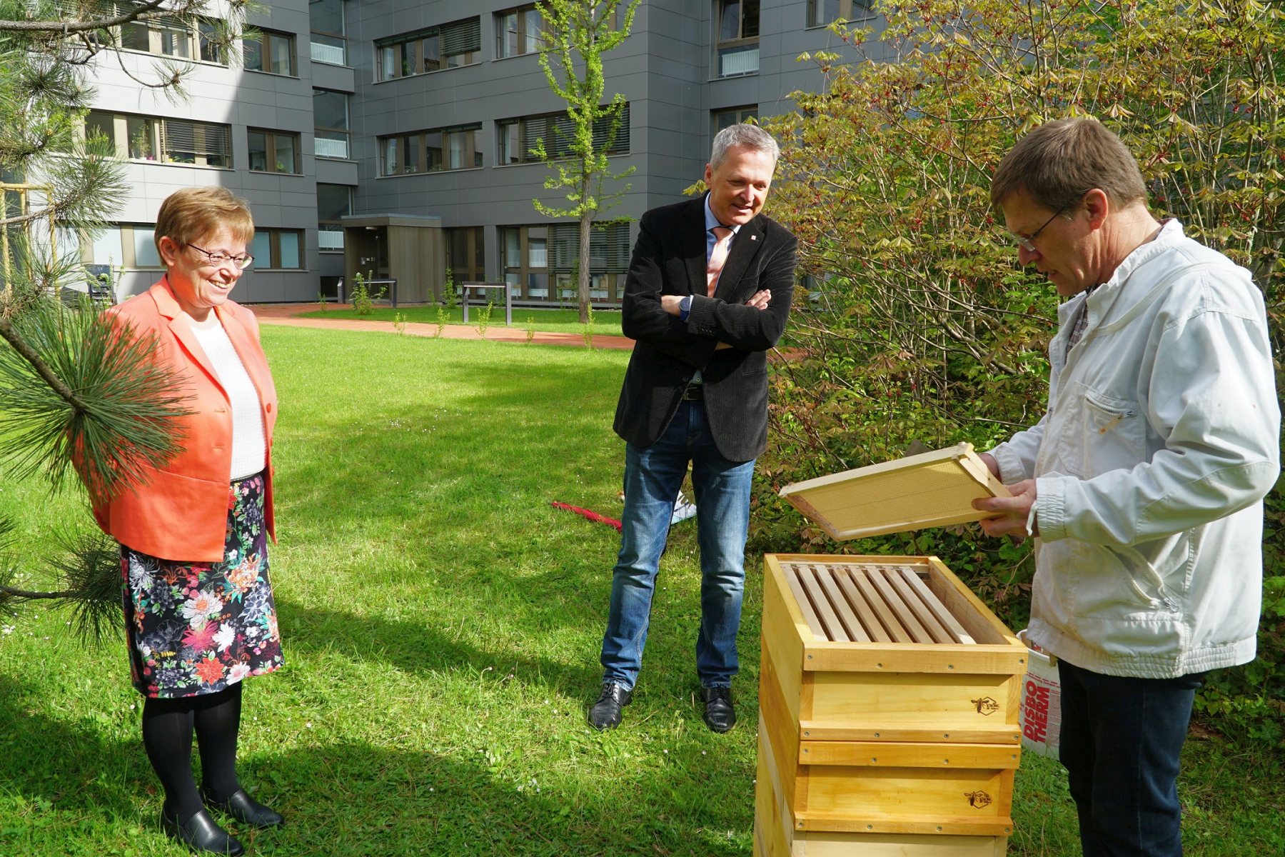 Regierungsvizepräsident Martin Rößler (Mitte) und Abteilungsleiterin Karin Ohm-Winter lauschen interessiert den Ausführungen von Imker Joachim Schönig.