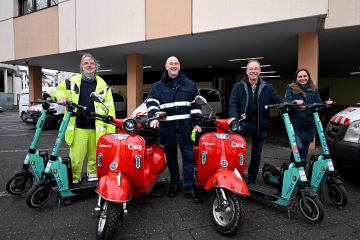 Zu sehen (v.l.n.r.): Georg Wolter, SWB-Mitarbeiter des Clara-Serviceteams, hat die Elektroroller und TIER-Scooter an Klaus Kapellner sowie Andreas und Miriam Löbbing vom Festausschuss Bonner Karneval übergeben. (Foto: Stadtwerke Bonn/Benjamin Westhoff)