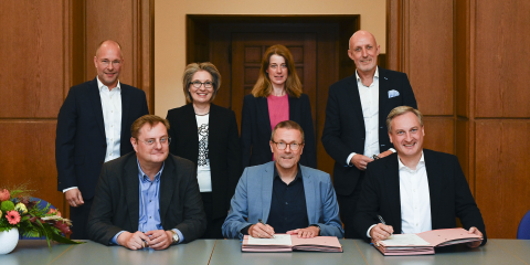 Peter Storch (Vorstandsmitglied WSW Energie & Wasser AG), Oberbürgermeister Uwe Schneidewind und WSW-Vorstandsvorsitzender Markus Hilkenbach (v.l.) bei der Unterschrift. Dahinter Dr. Frank Pieper (Geschäftsführer WSW Netz GmbH), Stephanie Barth-Krösche (L